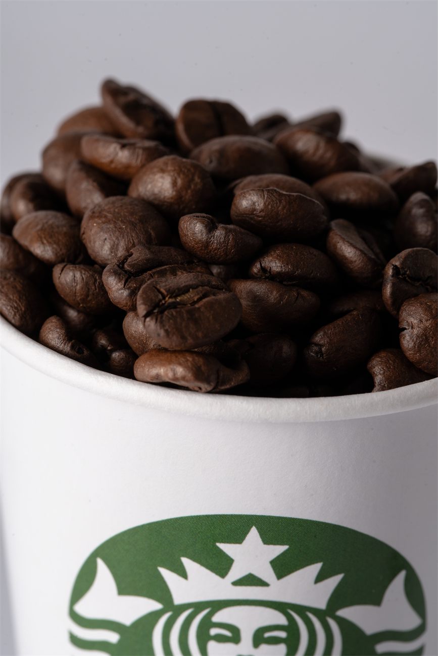 Copo de papel personalizado com a marca Starbucks cheio de grãos de café